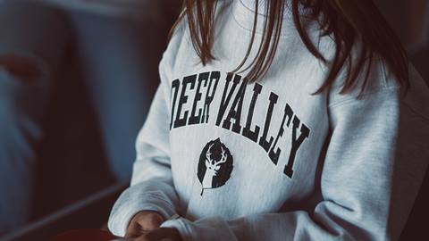 Girl wearing Deer Valley logo sweatshirt.