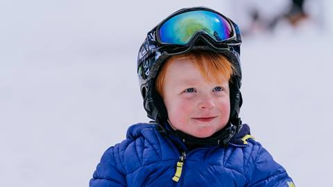 Young boy wearing blue ski jacket.