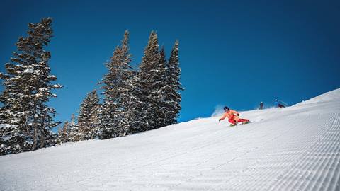 Woman skiing groomed run on a blue bird day at Deer Valley.