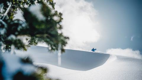 Man skiing powder on a sunny day at Deer Valley.