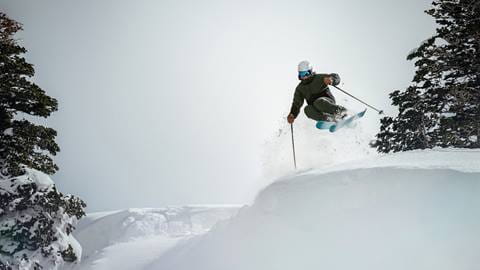 Skier doing a jump on a powder day at Deer Valley.