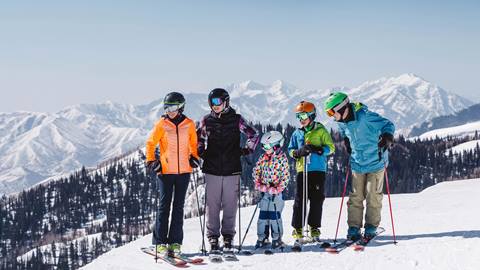 Family standing on ski run overlooking view of Deer Valley.