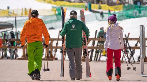 Deer Valley guest service employee assisting guests with their skis.