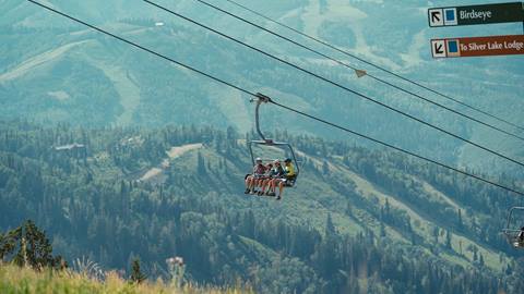 Family of four on a scenic chairlift ride in the summer at Deer Valley.